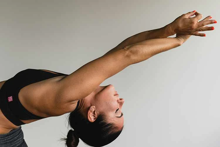 women performing a Pilates stretch arching back