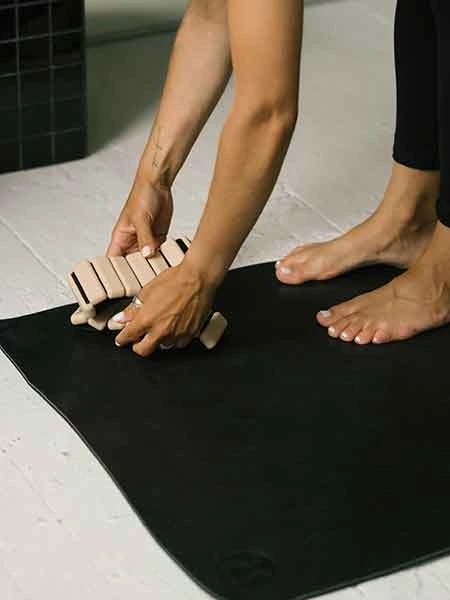 placing pilates ankle weights on a yoga mat demonstrating strength