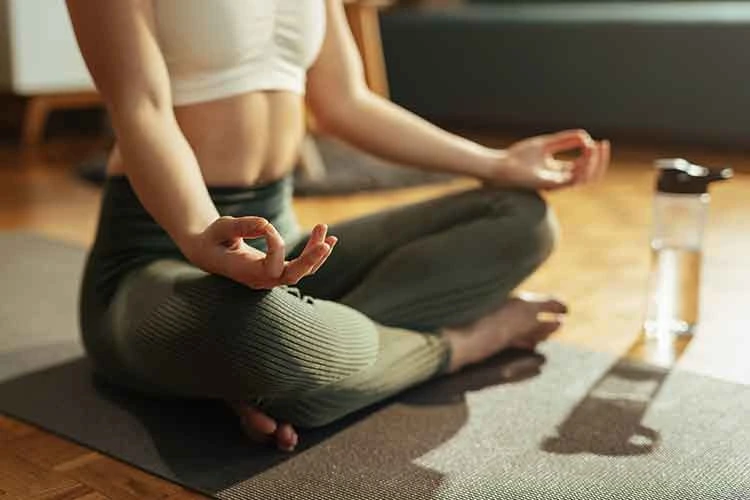 women doing a sitting yoga pose on mat